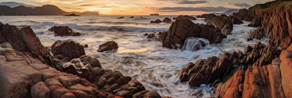 The waves are crashing over the rocks at sunset. photo