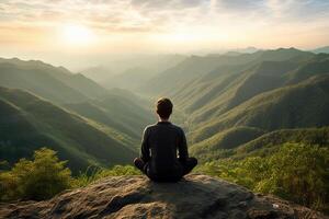 un persona meditando en parte superior de un colina, con vista a un vasto paisaje de montañas y bosque. ai generativo foto