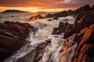 The waves are crashing over the rocks at sunset. photo