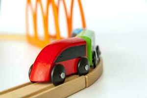 para niños ferrocarril hecho de madera en un blanco antecedentes. de madera de colores remolques juguetes para niños hecho de madera. foto