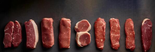 Set of different types of raw meat. Top view on the table. Black background. . photo