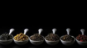Types of tea in a cup and leaves, healing tonic drink, black background isolate. . photo