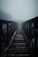 Old wooden bridge leading to nowhere in the fog, broken, gloomy dark blue, mysterious, loneliness. photo