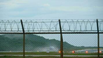 aereo atterraggio su il bagnato pista di decollo di Phuket aeroporto. video