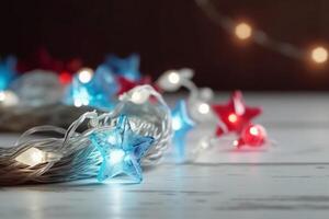 Christmas background with blue light luminous garlands and red stars on a white wooden background with copy space. photo
