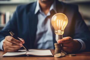 idea for save or investment. businessman holding lightbulb beside piggy bank and coins stacking on desk with note book. photo