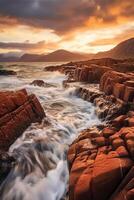 The waves are crashing over the rocks at sunset. photo