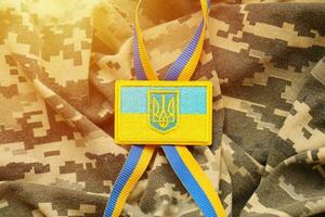 tela de camuflaje militar con bandera ucraniana en chevron uniforme foto