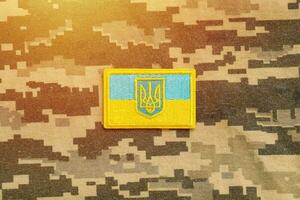 Military camouflage fabric with ukrainian flag on uniform chevron photo