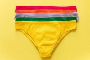 Set of colorful underpants on yellow background, close up photo