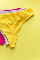 Set of colorful underpants on yellow background, close up photo