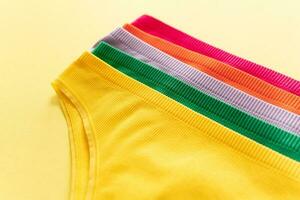 Set of colorful underpants on yellow background, close up photo