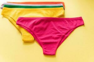 Set of colorful underpants on yellow background, close up photo