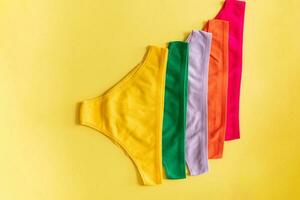 Set of colorful underpants on yellow background, close up photo