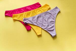 Set of colorful underpants on yellow background, close up photo