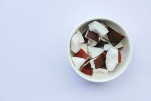 slice of fresh coconuts in a bowl on white background photo