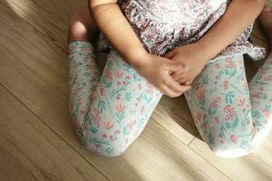 child sitting W posture on the floor . photo