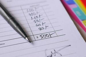 A man writes payment due in a paper form photo