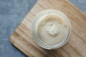 close up of Mayonnaise in container on table . photo