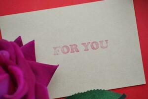rose flower and gift card with for you text on it photo