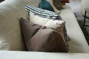 moderno gris sofá con almohadas en vivo habitación a hogar foto