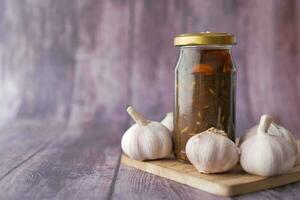 pepinillo de ajo casero en un frasco de vidrio sobre la mesa, foto