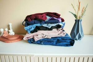 Stack of clothes on table indoor. photo