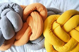 gray, orange and yellow color pillow on bed photo