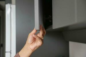 man's hand open drawer wooden in cabinet photo