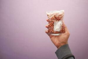 peeled peanuts in a plastic packet on hand photo