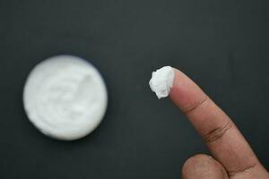 man applying beauty cream onto skin photo