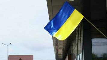 The national flag of Ukraine flutters in the wind on a flagpole, on a building. Blue and yellow colors on the Ukrainian flag. Flag of Ukraine on the facade of the government building. video