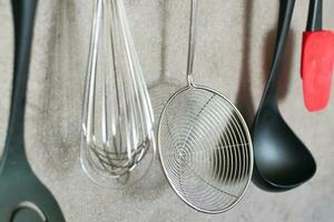 kitchen utensils hanging on gray background. photo