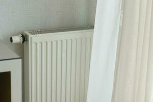 heating radiator under window in the room photo