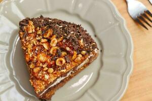 chocolate, nut and cream cake on a plate on table photo