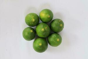 Green lemons with on a white background photo