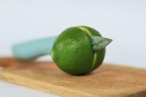 Green limes sliced on a cutting board on a white background photo