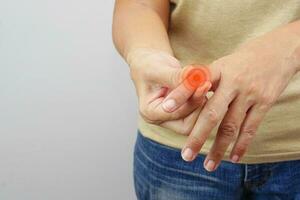 Focus of woman finger suffering from knuckle pain on white background. Healthcare and office syndrome concept. photo