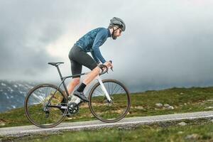 Cyclist athlete pedals uphill photo