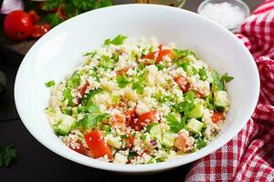 Traditional Lebanese Salad Tabbouleh. Couscous with parsley, tomato, cucumber, lemon and olive oil. Middle Eastern cuisine. photo