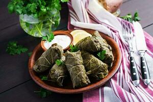 Dolma. Stuffed grape leaves with rice and meat on dark table. Middle eastern cuisine. photo