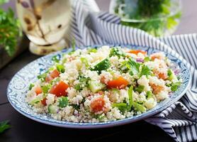 Traditional Lebanese Salad Tabbouleh. Couscous with parsley, tomato, cucumber, lemon and olive oil. Middle Eastern cuisine. photo