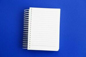 Top view of blank note paper on blue background photo