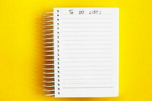 Top view of blank note paper on yellow background. to do list photo