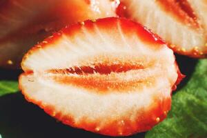 strawberry cut in half. strawberry core. half of a strawberry on a green background photo