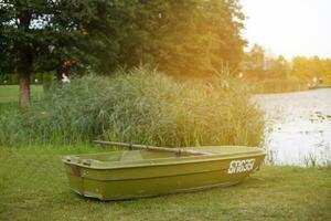 a boat on the grass of the shore of calm lake photo