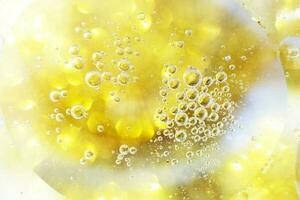 Gold Oil bubbles close up. circles of water macro. abstract shiny yellow background photo