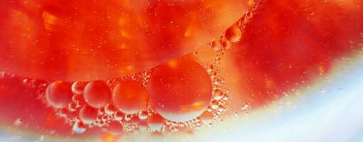 Oil bubbles close up. circles of water macro. abstract orange and fiery red background. banner photo