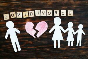 Paper chain cut family with broken heart on wooden background. divorce in the covid pandemic photo