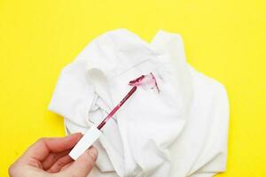 mujer mano participación rojo lápiz labial cerca blanco camisa con diario vida manchas foto